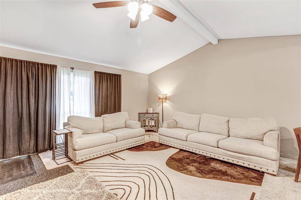 Spacious living room with high ceilings, abundant natural light, and a cozy, neutral palette perfect for relaxation and entertaining.