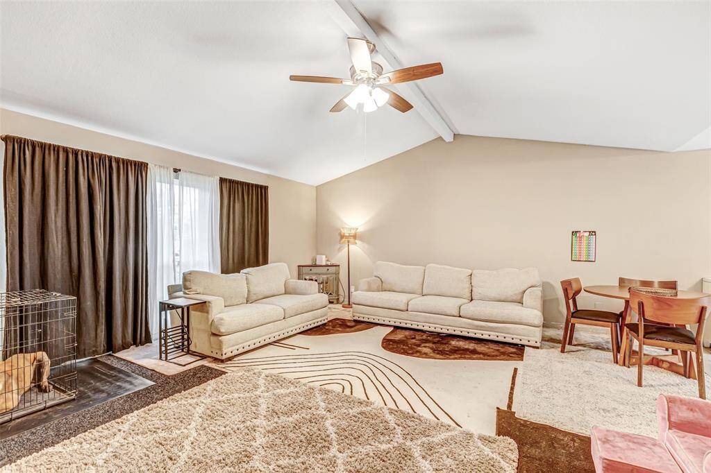 Spacious living room with vaulted ceilings, elegant lighting, and ample natural light. Perfect for relaxation and entertaining.
