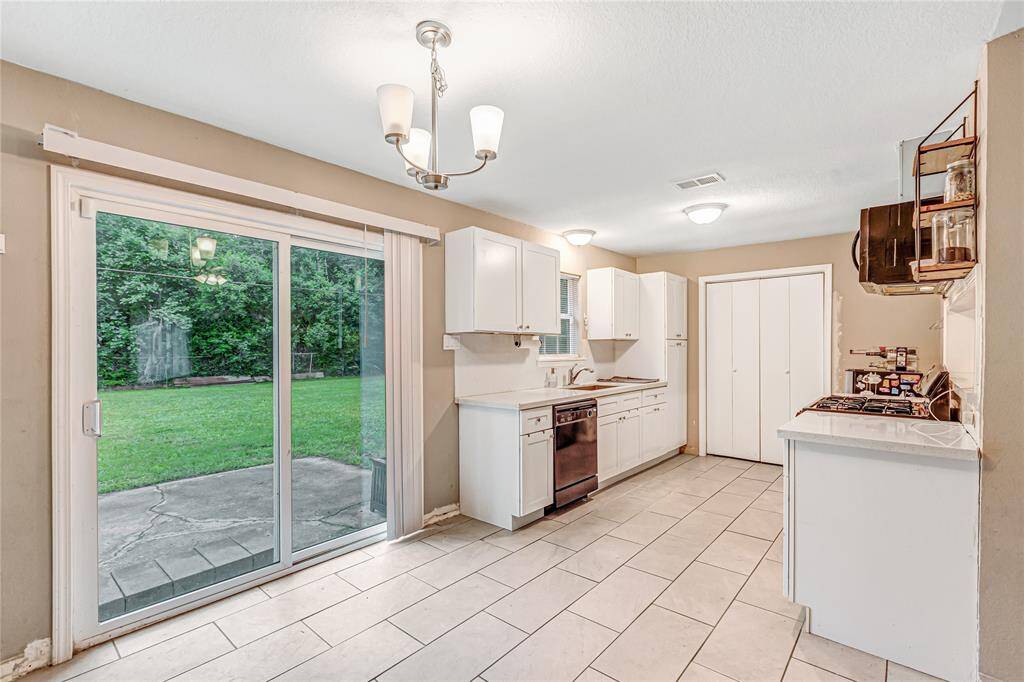 Spacious kitchen with modern appliances, ample storage, and large sliding doors leading to a lush backyard. Perfect for entertaining and family gatherings.