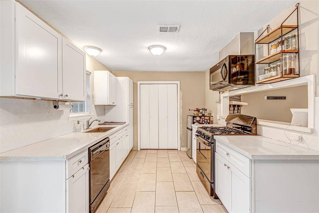 Modern kitchen featuring sleek white cabinetry, stainless steel appliances, and ample counter space for all your culinary adventures.