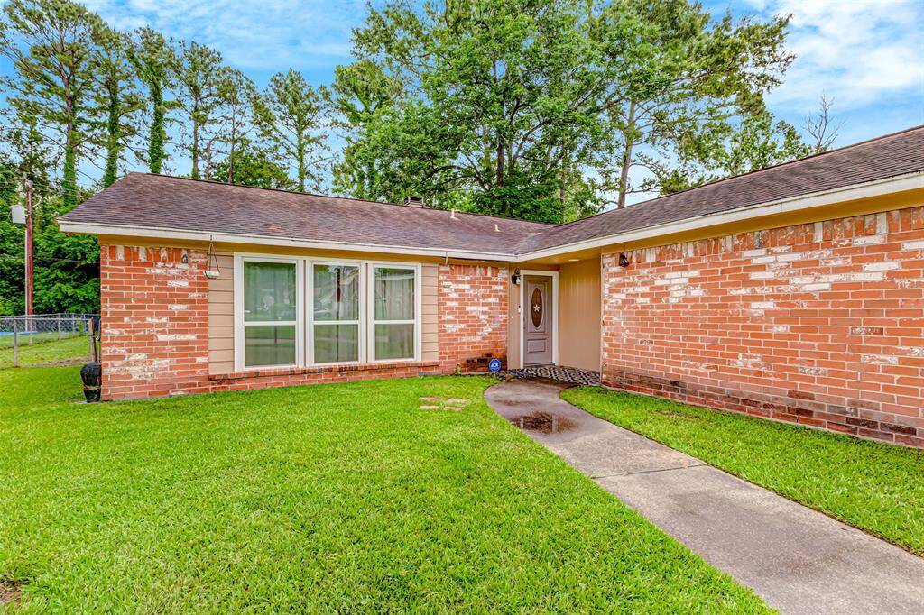 Charming brick home with inviting entrance, surrounded by lush greenery for a perfect blend of comfort and curb appeal.