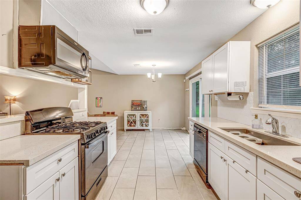 This bright, spacious kitchen features modern appliances, sleek countertops, and ample storage, perfect for culinary enthusiasts.