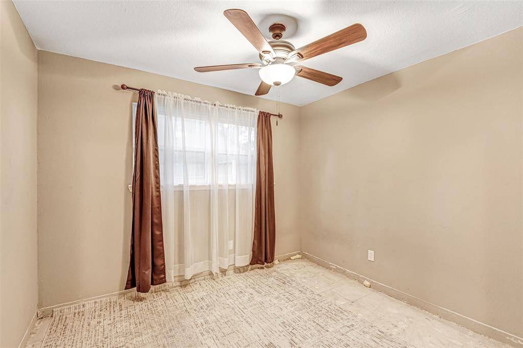 Cozy bedroom featuring natural light, elegant curtains, and a stylish ceiling fan. Perfect for relaxation and comfort.