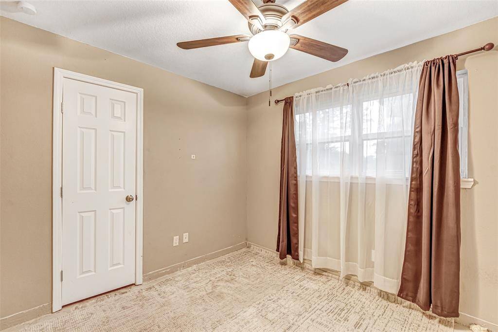 Elegant bedroom featuring warm tones, ample natural light, and a stylish ceiling fan for comfort.
