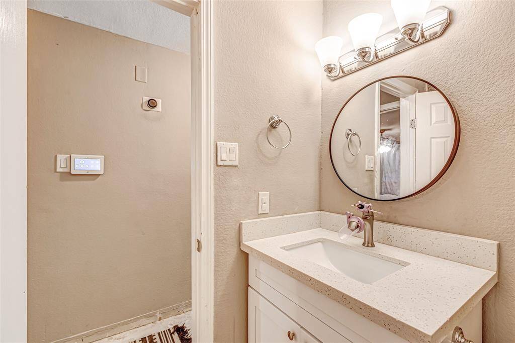 Chic and inviting guest bathroom featuring a modern vanity, sleek round mirror, and stylish lighting. Perfect for visitors!