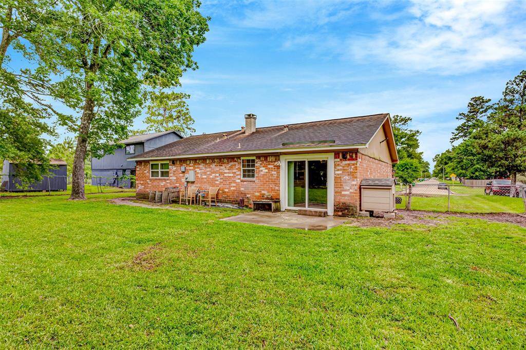 Spacious backyard with a charming brick exterior and large sliding doors, perfect for outdoor entertaining and enjoying the serene surroundings.