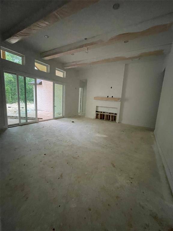 Family Room with Slider Doors to the Covered Rear Patio, Ceiling Beams, and Fireplace.