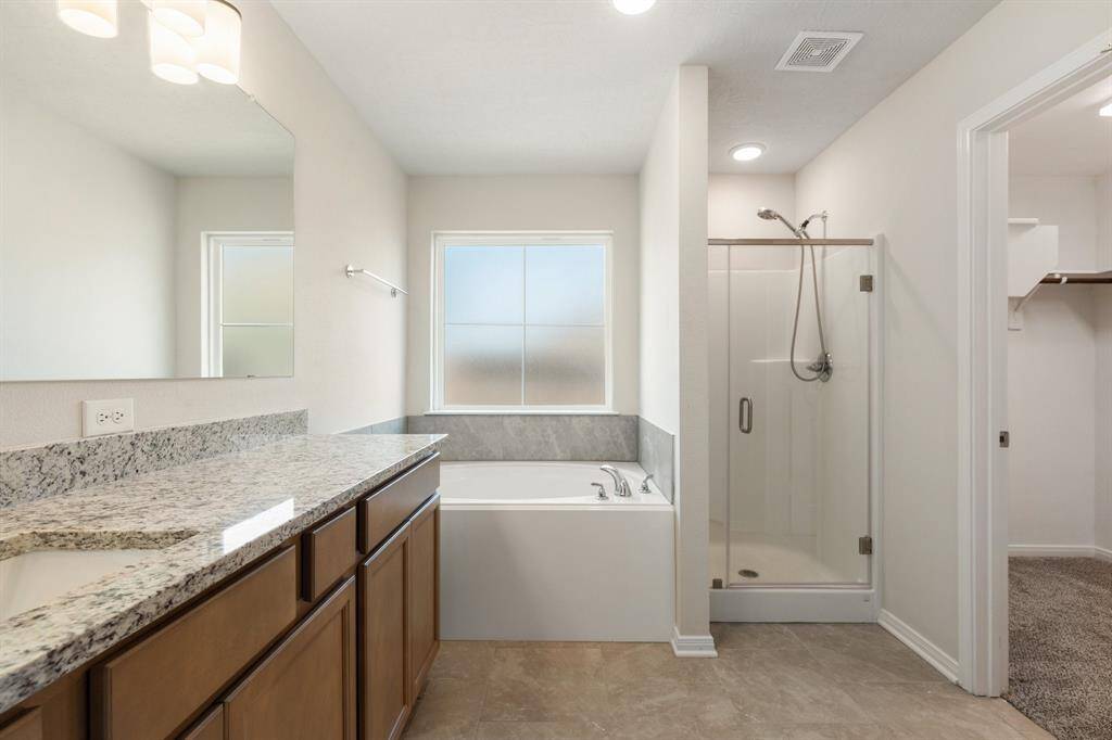 With a luxurious soaking tub and separate walk in shower, this primary bathroom is the perfect place to unwind and relax after a long day.