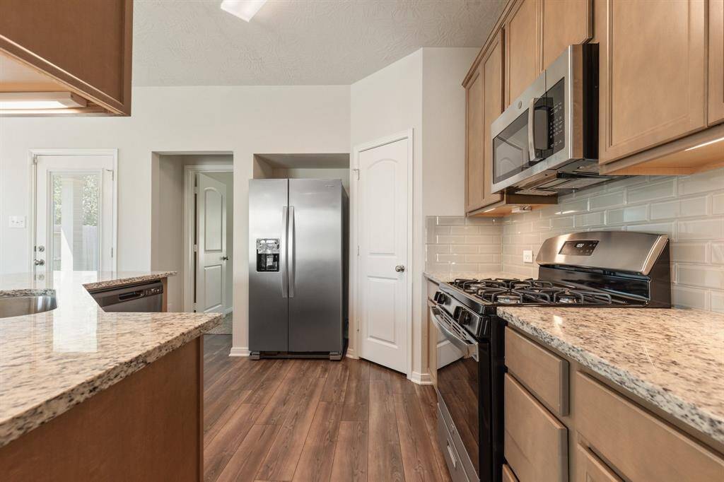 Contemporary touches include 42" cabinets, under cabinet lighting and sleek glass tile backsplash.