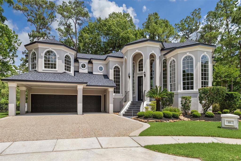 This stunning home features a grand façade with large arched windows and elegant columns. The well-manicured landscaping and spacious driveway enhance its curb appeal. Ideal for luxury living.