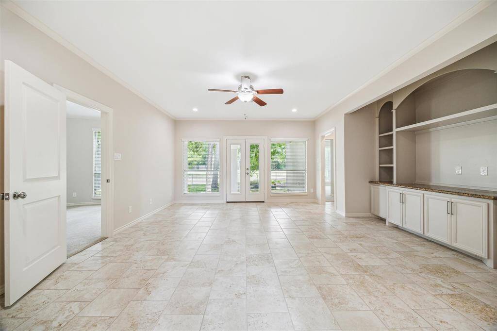 Living area with a built-in entertainment center has access to the covered porch.