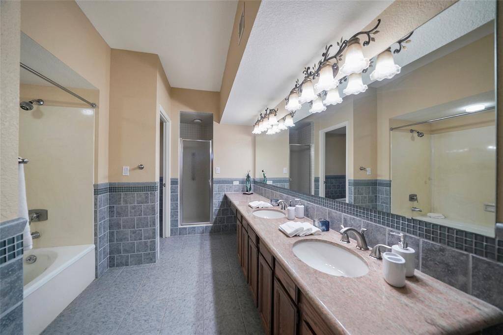 The primary bathroom includes double sinks, a separate shower and tub, and plenty of counter space—designed for both function and comfort.