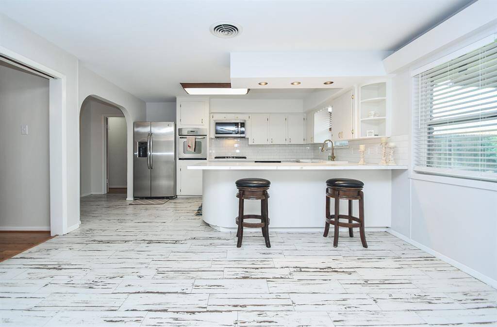 Wide arched doorways lead to bedrooms, while a fully equipped kitchen keeps the home fires burning everyday and on special entertaining days, too!