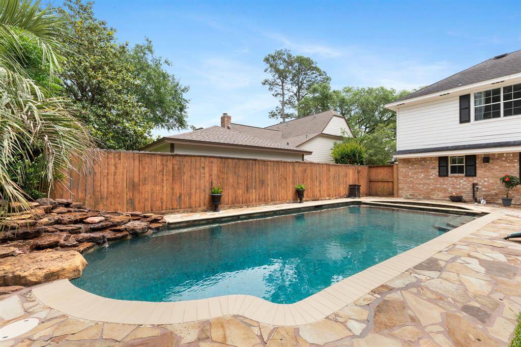 Incredible backyard pool and spa with rock feature and beautiful stone decking. There is also a half bathroom outside by the pool and an outdoor shower!