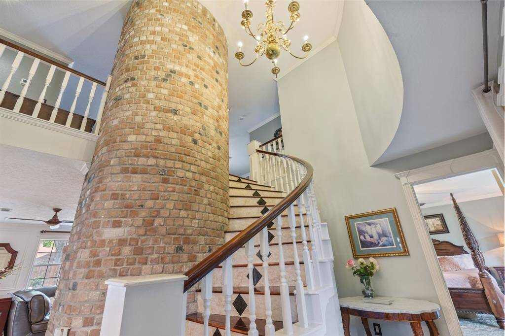 As you enter the home, you are greeted by this striking curved brick wall that adorns the staircase and contributes to the great character of the home
