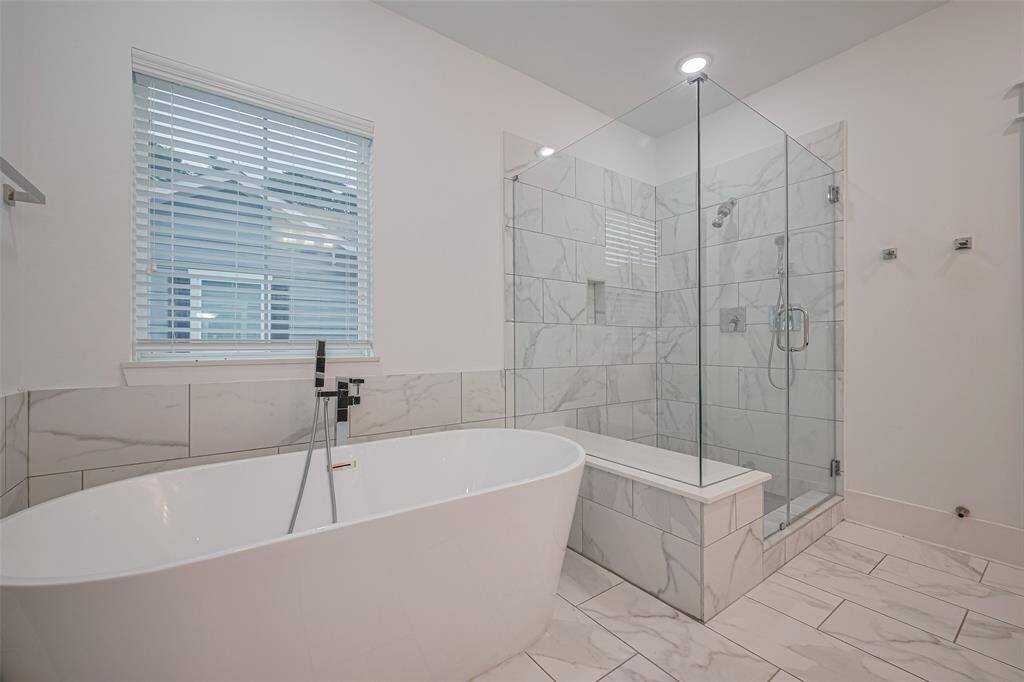 Freestanding soaking tub and walk-in shower for the primary bath.
