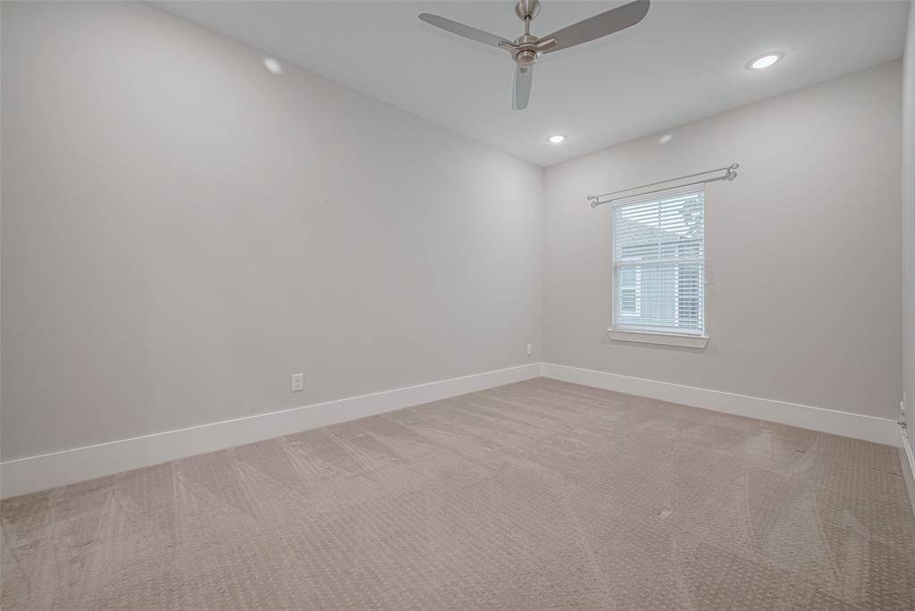 Upstairs secondary bedroom with ceiling fan, window treatments and en suite bathroom.