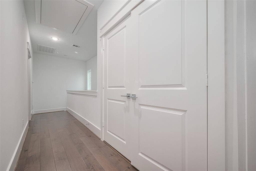 Upstairs hallway with laundry zone to the right which houses the included washer/dryer.