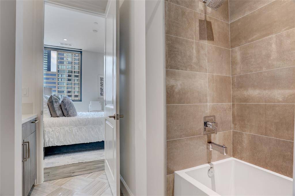 From this perspective, you get a view of the second en-suite bathroom, highlighting the combination tub and shower. You can also catch a glimpse of the second bedroom beyond.