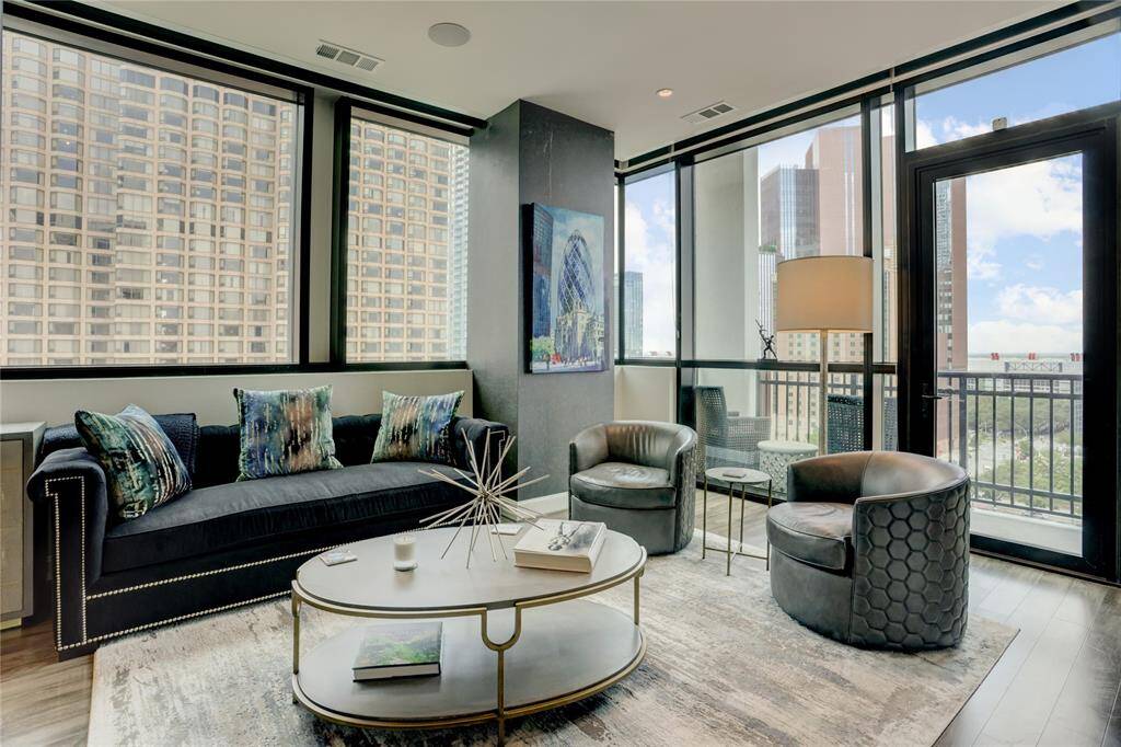 A closer look at the living area, filled with natural light from floor-to-ceiling windows. The glass door leads to your private balcony, offering stunning city views and the perfect spot to unwind.