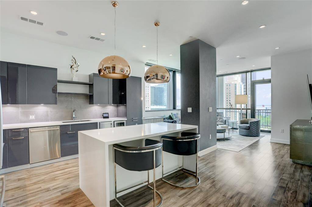 As you pass the entryway, you’re welcomed by a modern kitchen with sleek cabinetry, stainless steel appliances, and an open layout that flows effortlessly into the living space, perfect for both everyday living and entertaining.