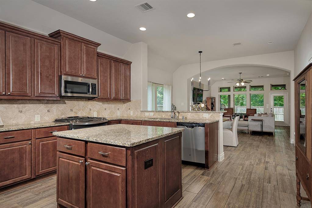 Open concept kitchen flows around a center island and opens to dining and living areas