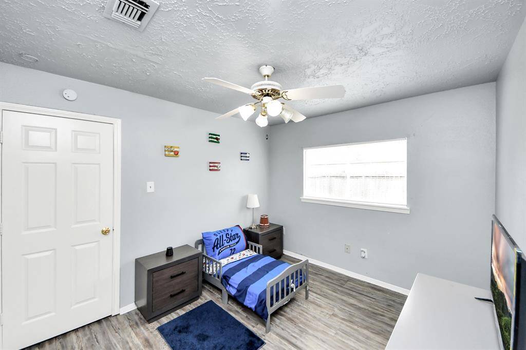 Bright, modern kitchen featuring white cabinetry, granite countertops, and stainless steel appliances. Large windows offer plenty of natural light, and the open layout connects to the dining area.