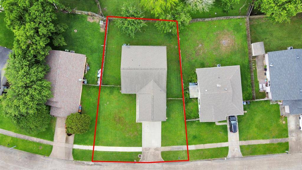 This photo shows the backyard of a home featuring a spacious yard and covered patio space.