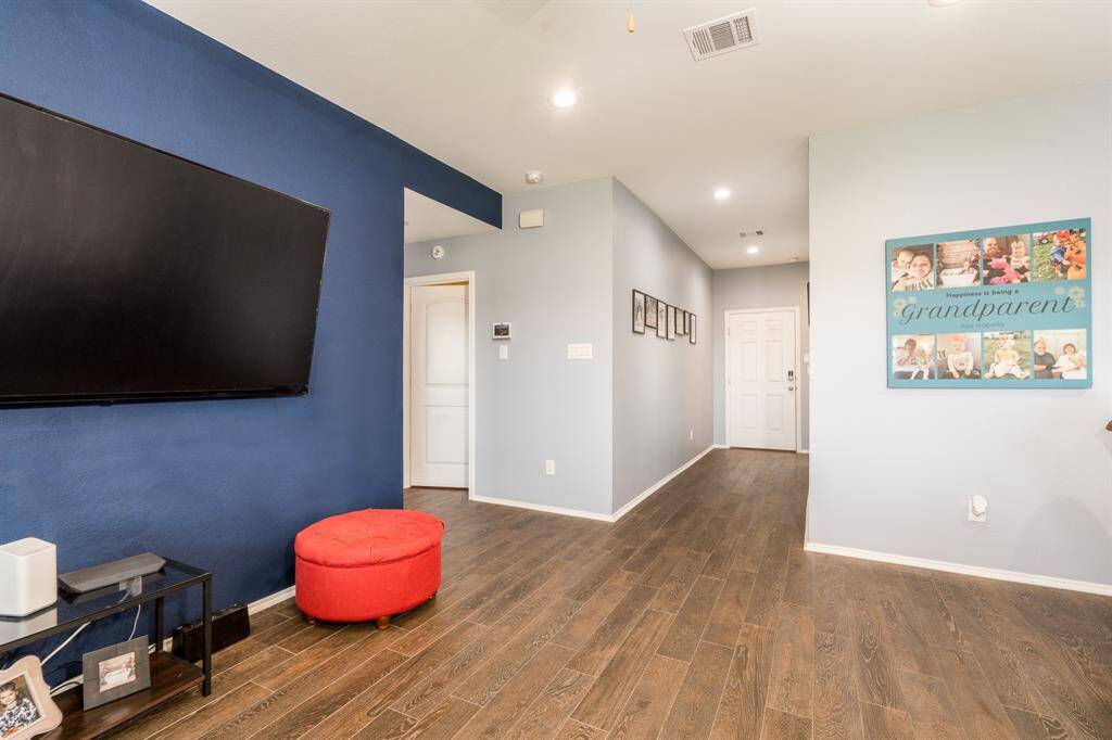 A long hallway off of the family room leads to the front door and the secondary bedrooms in this split floor plan.