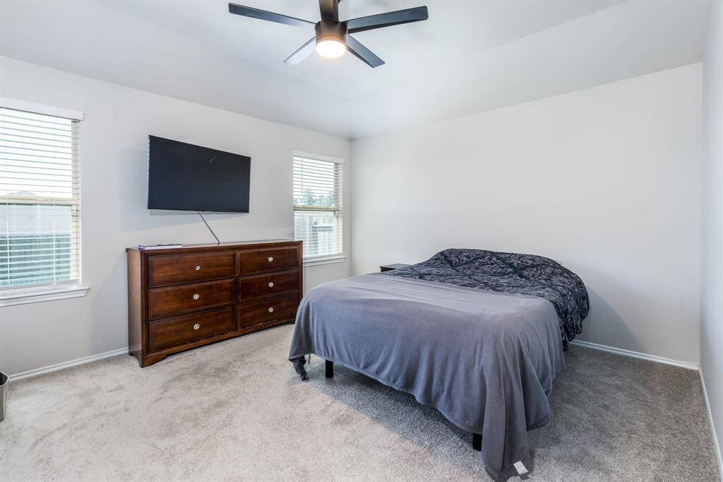 The primary bedroom sits at the back of the house. This TV also conveys with the house.