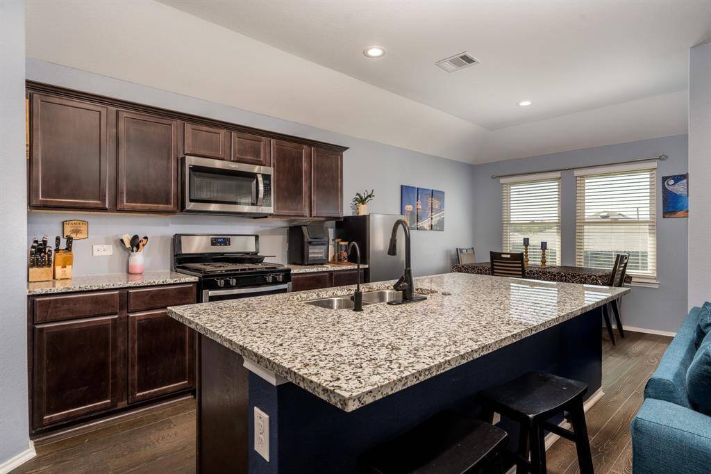Rich wood cabinets and a large island in the open concept floor plan.