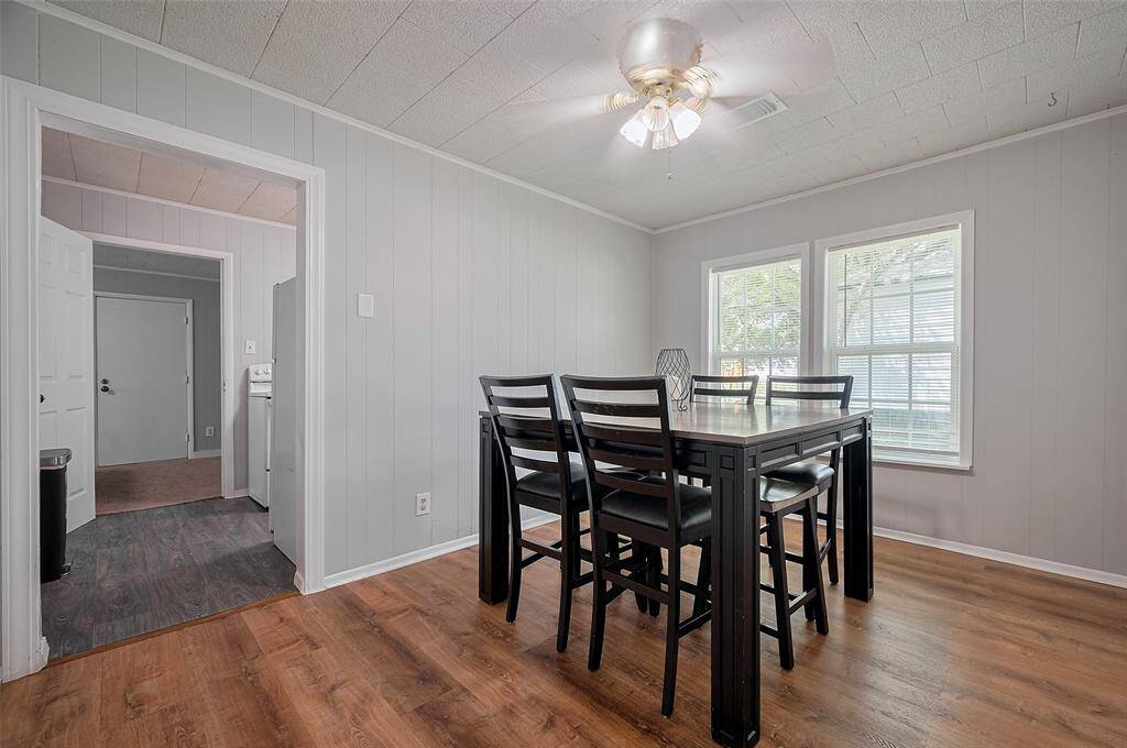 The dining area basks in sunlight from a large window and connects to the kitchen—perfect for everyday meals or entertaining with ease.
