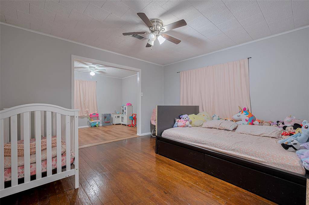 This secondary bedroom expands into an adjoining bonus space—perfect for a playroom or creative space. Both areas feature ceiling fans for added comfort.