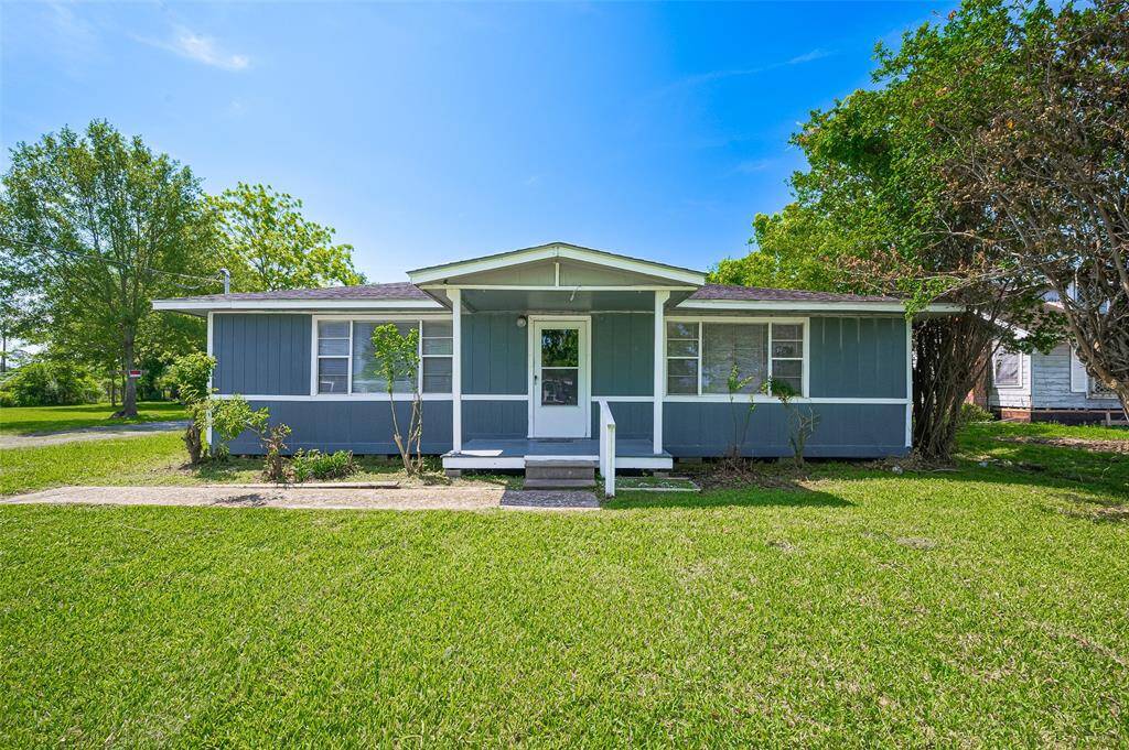 The second house mirrors the charm of the first with blue siding and crisp white trim. An elevated porch adds character and a welcoming entry point.