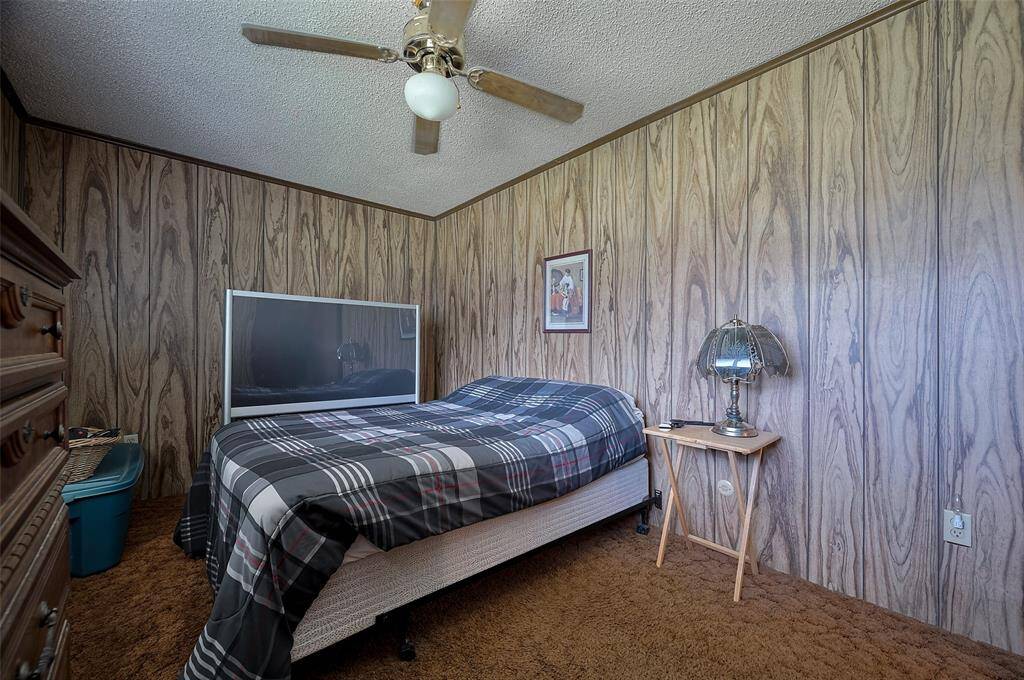 The wood-like paneling continues into this carpeted bedroom, creating a warm and restful space to end the day.