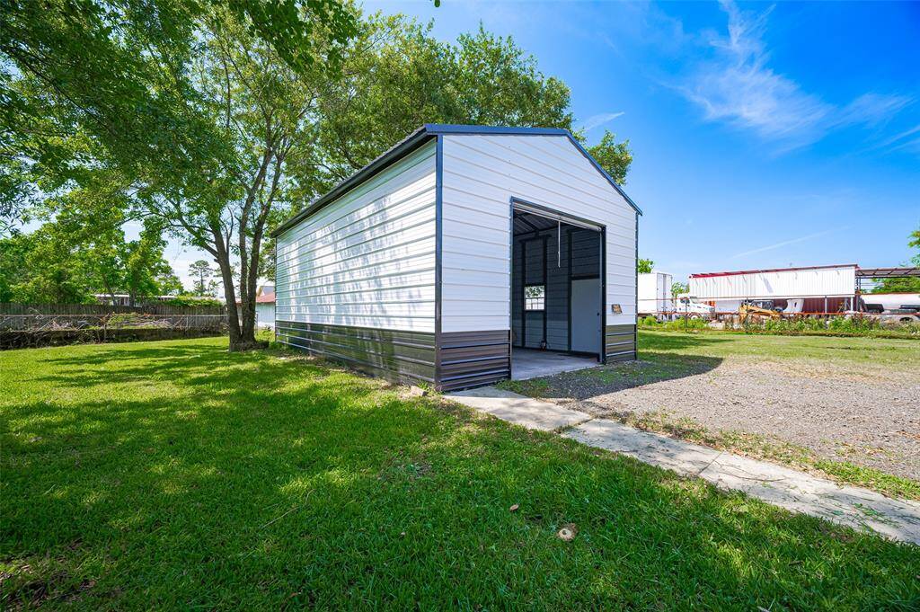 The large detached garage is more than a place to park—it doubles as a workshop and storage hub, with space for tools, projects, and potential.