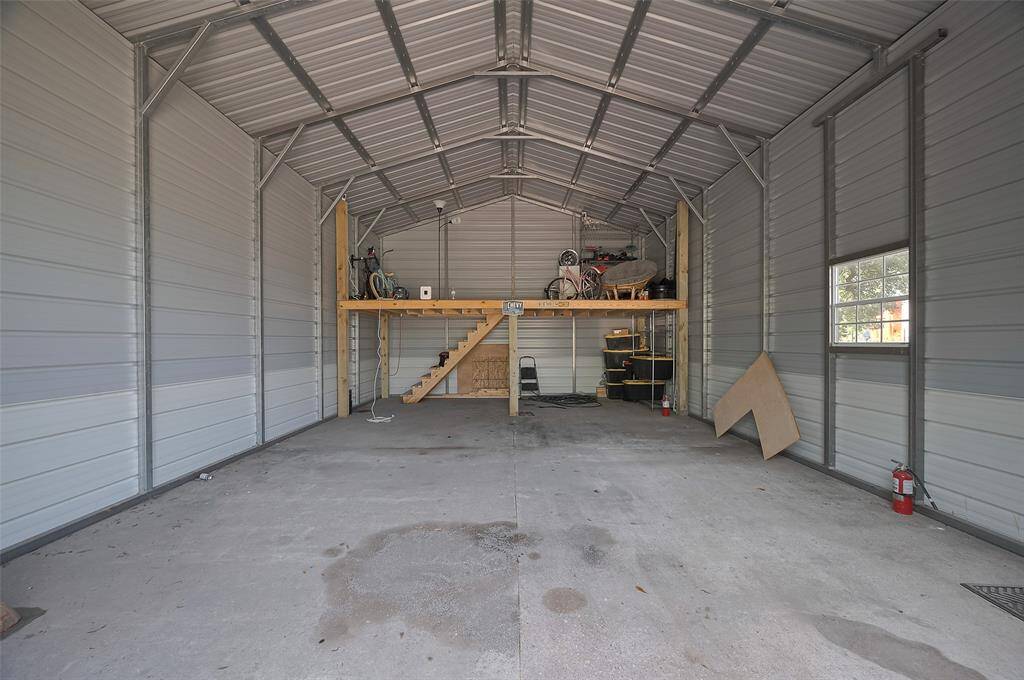 Inside the garage/workshop, the possibilities multiply. A loft area adds usable vertical space while the main floor boasts high ceilings, a window, and ample room for equipment or creativity.