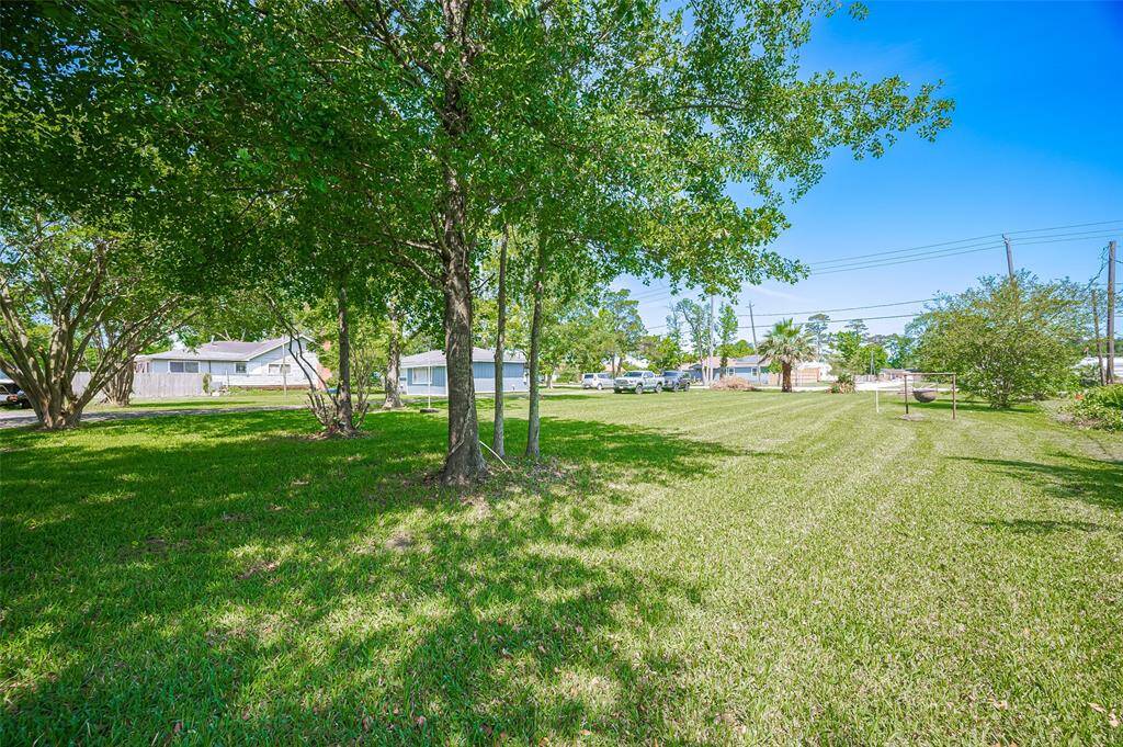 A wide view of the property showcases the full expanse of lush grass and tree-dotted landscape. This isn’t just a lot—it’s land that invites imagination, productivity, and growth.