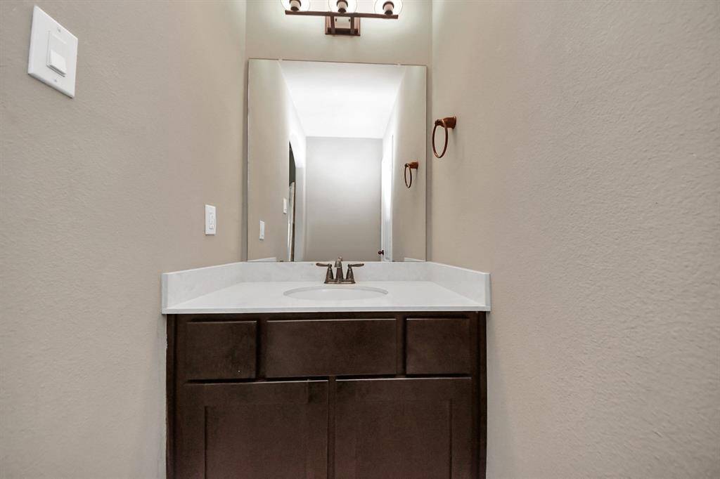 Stylish powder room featuring a contemporary sink and mirror.