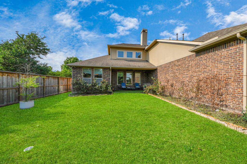 Spacious backyard with a well-maintained lawn and a covered patio area.