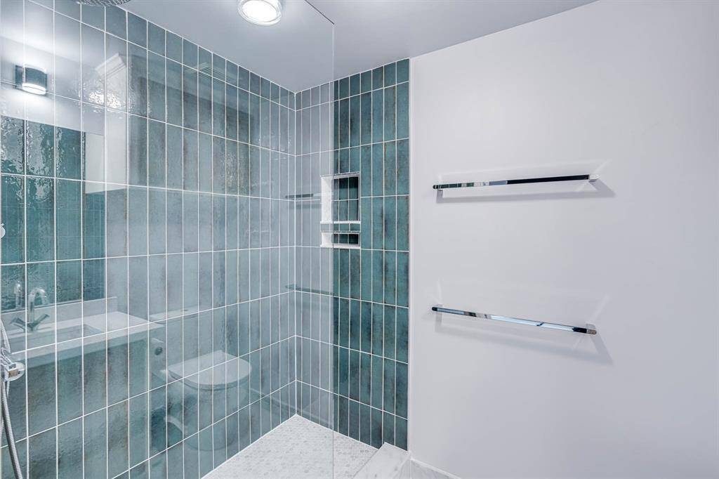 Spa-inspired bathroom with a stand-up shower enclosed by a frameless glass panel, offering a clean and contemporary look