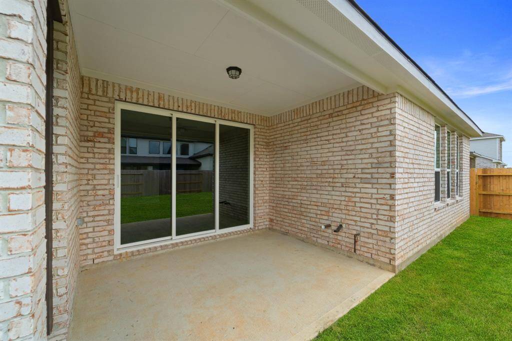 The covered patio is generously sized, providing ample space for various outdoor activities.