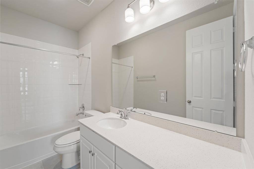 The secondary bath features tile flooring, white cabinetry and light countertops and a shower/tub combo. Perfect for accommodating any visiting family and friends.