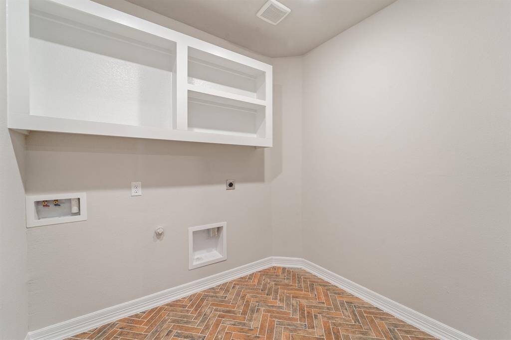 The laundry room layout is carefully planned for optimal workflow with designated areas for washing, drying, and storing.