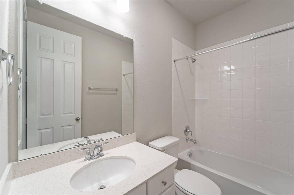 The secondary bath features tile flooring, white cabinetry and light countertops and a shower/tub combo. Perfect for accommodating any visiting family and friends.