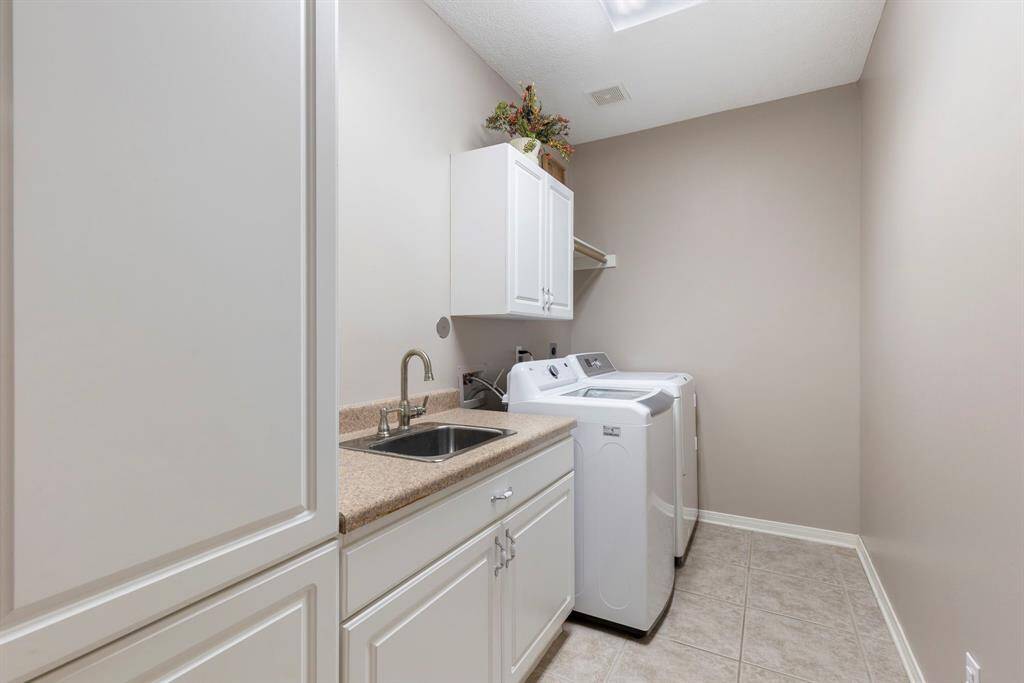 Explore the practicality and convenience of the well-designed utility room, featuring a spacious layout that enhances everyday tasks. Equipped with a sink and custom cabinets, this room offers ample storage and organization solutions, making laundry and household chores a breeze. The nice size of the utility room ensures you have plenty of space to work efficiently, while the thoughtful design elements add a touch of style and functionality