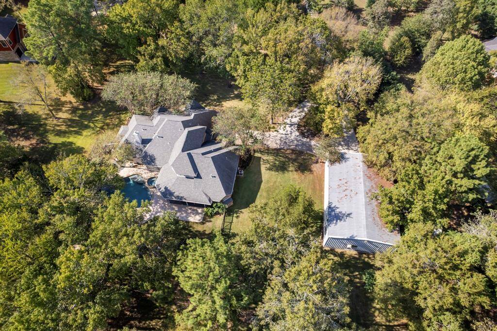 This wooded property offers unparalleled privacy on nearly 5 acres, as highlighted by the aerial view.