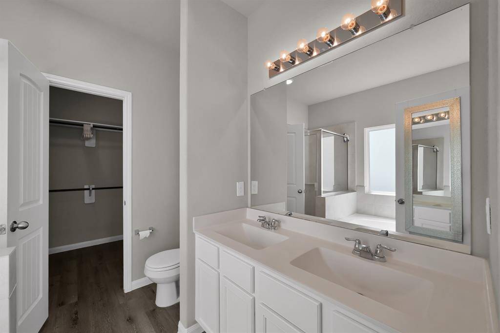 Primary bathroom with double sinks and spacious closet.
