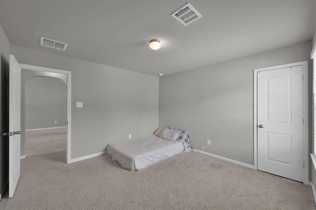Comfortable carpeted bedroom with ample natural light.