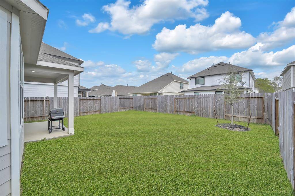 Fenced backyard with covered patio, perfect for outdoor living.